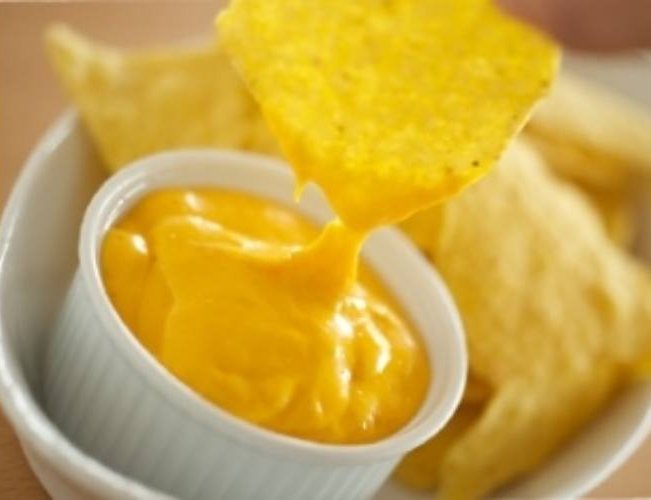 Nachos chips sajtszószba mártva